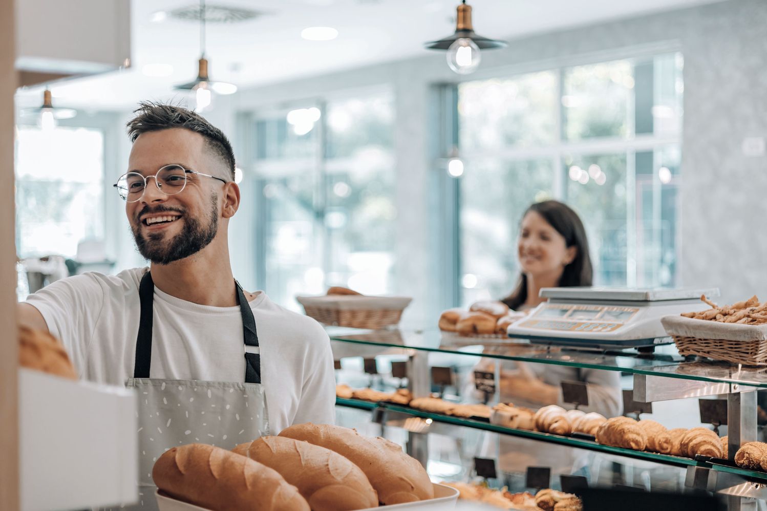 Man taking bread from a shelf in a bakery